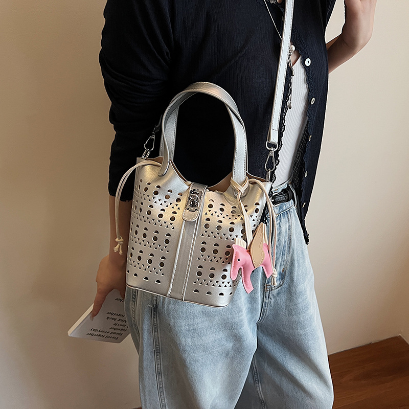 Nicho de diseño hueco bolsa de canasta de verduras para mujeres 2025 verano nueva moda alta sensación bolso de cubo de agua