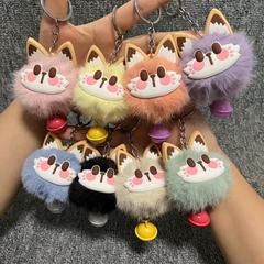 ウサギの毛をまねてかわいい招き猫は鈴のぬいぐるみのペンダントのキーホルダーを持っています。