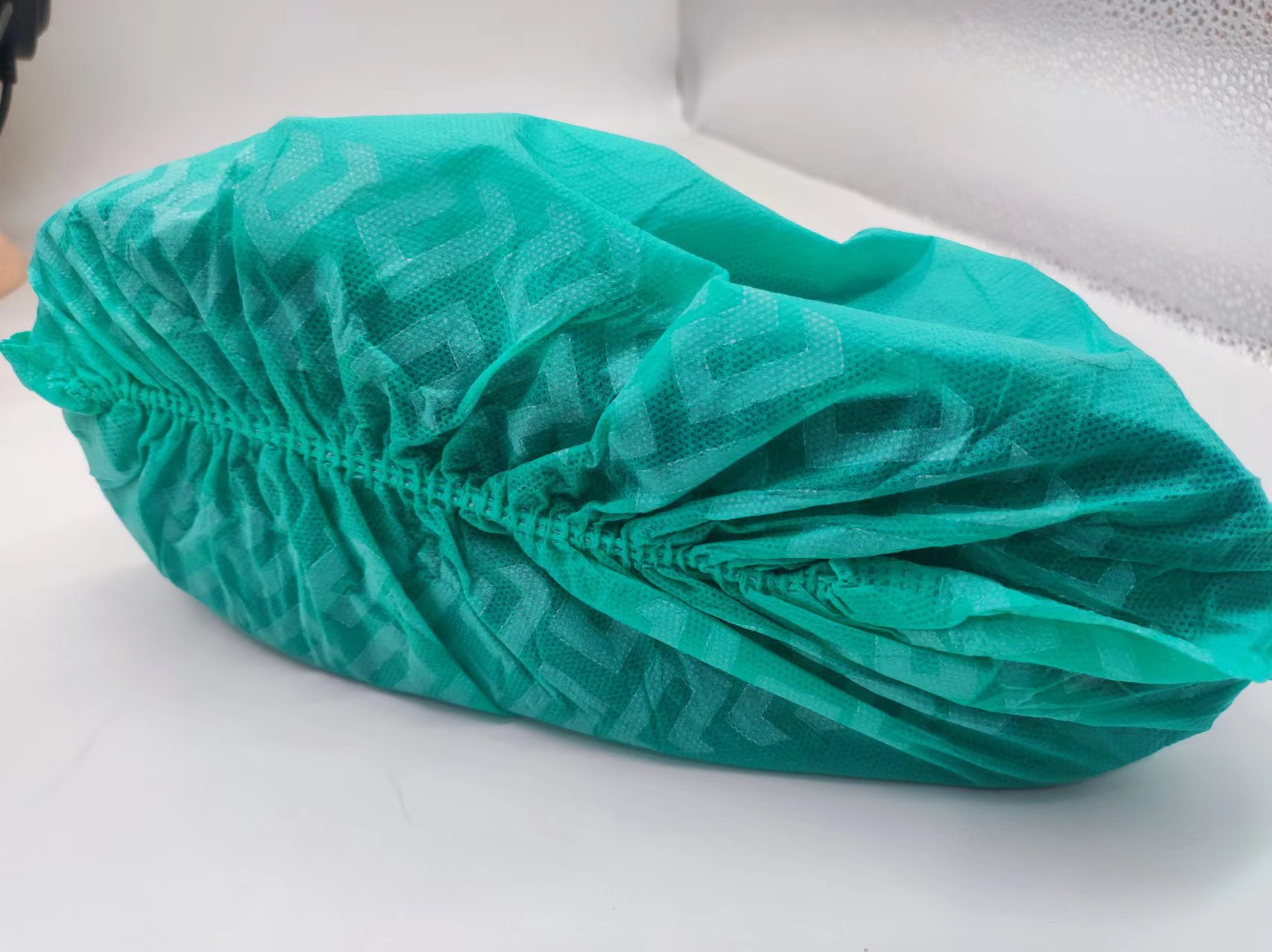 Cubierta de zapato antideslizante no tejida desechable al por mayor a prueba de polvo transpirable engrosada cubierta de zapato no tejida cubierta de zapato impresa en negro