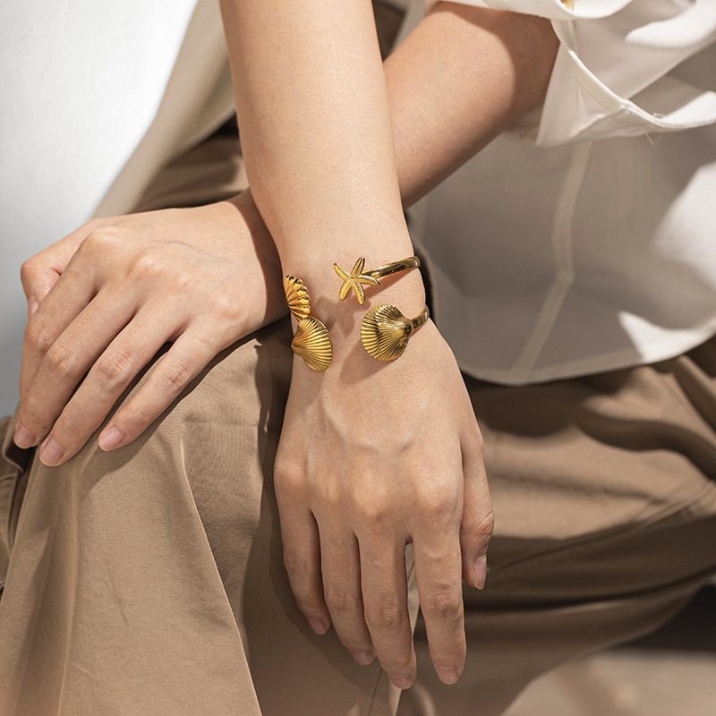 Tena Europa y América Pulsera de acero inoxidable Mujer de alta gama Ocean Beach Nuevo estilo Shell Estrella de mar Juego de joyería de mano al por mayor