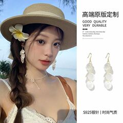 リゾート風の長い貝殻のイヤリングは夏の海辺のフリンジのイヤリング感があります。