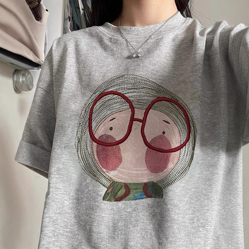 純綿の灰色の肩の半袖のtシャツの婦人服の2025夏のアメリカの漫画のプリントのファッションのギャルの上着|undefined