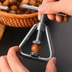 ナッツの神器のクルミのアーモンドのハワイの果物を開けて殻を開けます。