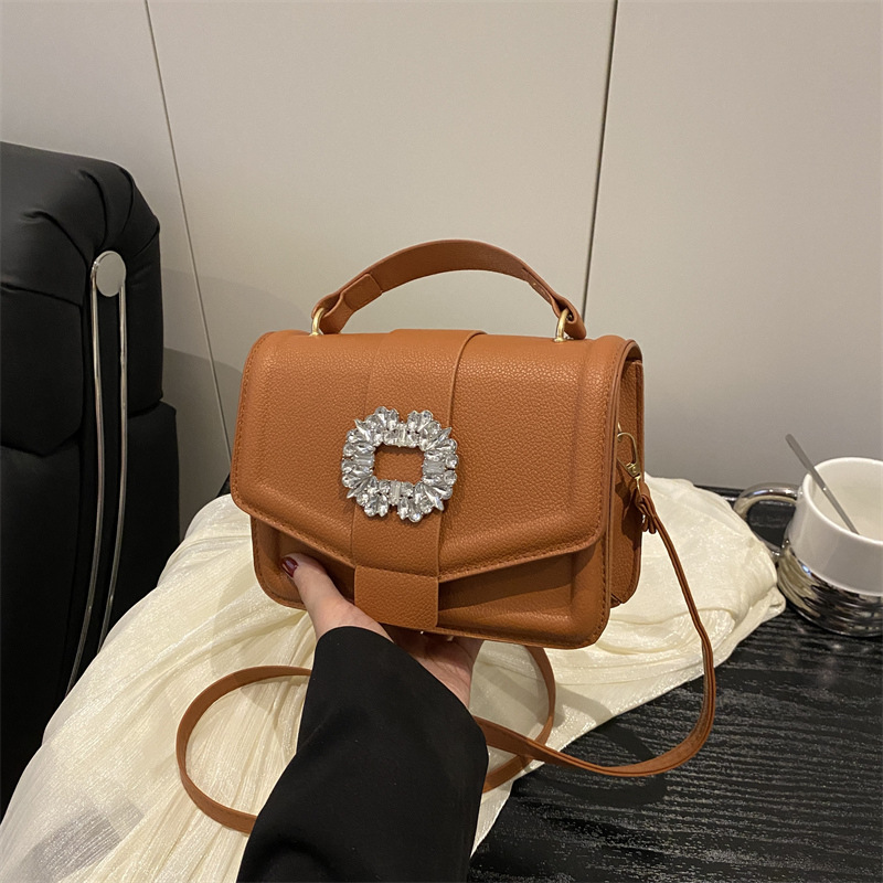 Bolso popular este año 2025, nuevo estilo simple de moda, mochila con patrón de litchi, bolso de viento simple, bolso de hombro casual.