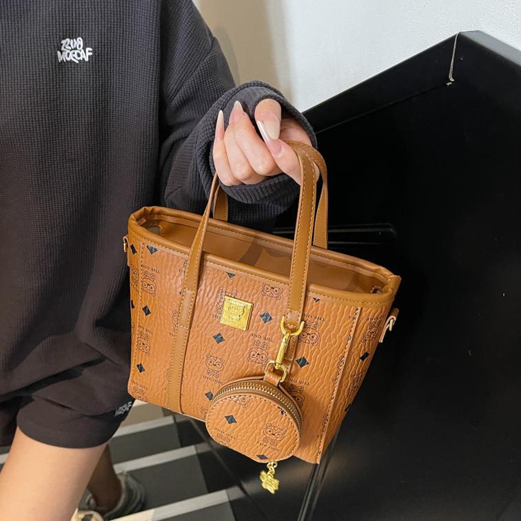 Bolsa de cubo portátil de impresión de moda super caliente para mujeres 2025, nuevo bolso de hombro de nicho universal, bolso de cinturón en línea.