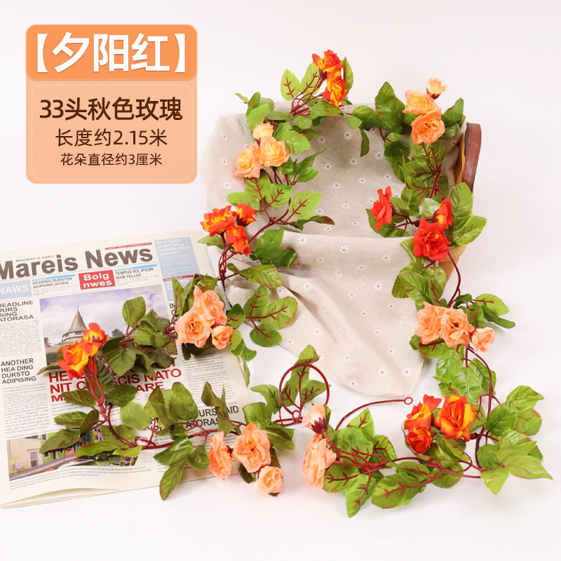 Simulación de flores falsas rosas de caña colgando la pared tubería de drenaje envuelta hoja verde que cubre la parte superior de la decoración de boda de plástico