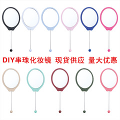 手に楕円のdiyビーズの小さい鏡を持って携帯します。