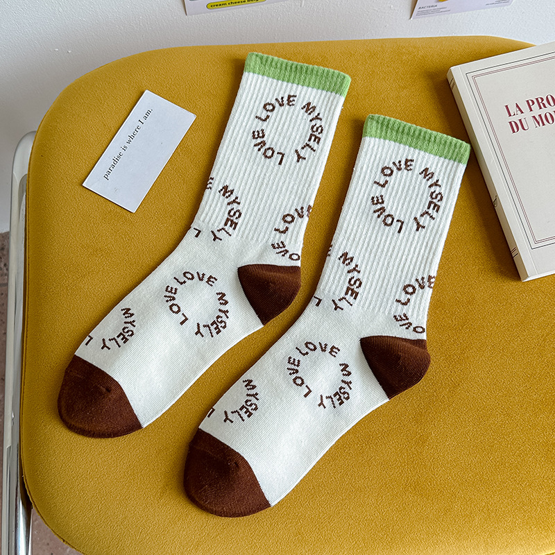 Calcetines de algodón de color puro Mediados de la pantorrilla de las mujeres Otoño e invierno Letras blancas Calcetines de marea de alta elástico Calcetines deportivos al por mayor