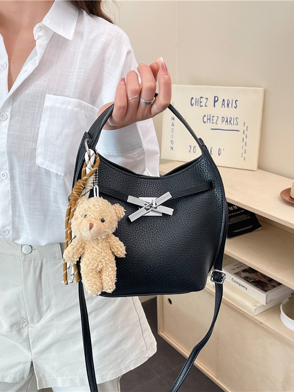 Un sentimiento de alto nivel de oso colgante bolso de cubo portátil para mujeres 2026 nuevo litchi nicho viaje mochila de hombro