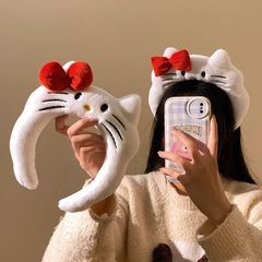 かわいい赤い蝶結びのkittyのぬいぐるみの広いカチューシャの女性の顔を洗ってマスクのカチューシャのカチューシャの写真を撮ります。