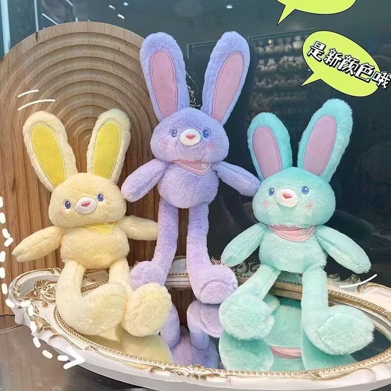 ネットの赤い耳のウサギはウサギの鍵を引いてぬいぐるみのかばんのペンダントを掛けて女の子にプレゼントします。|undefined