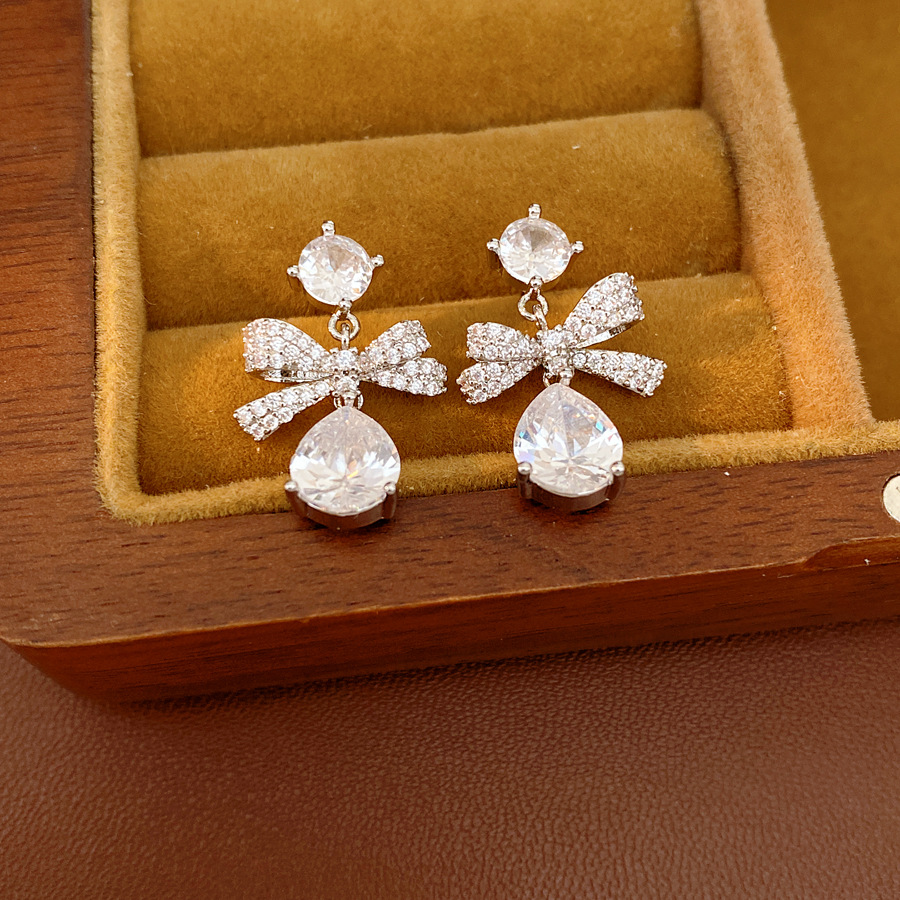 Aguja de plata zircon arco gotas de agua simple temperamento moda aretes de aretes ligeros de lujo alta sensación de aretes al por mayor