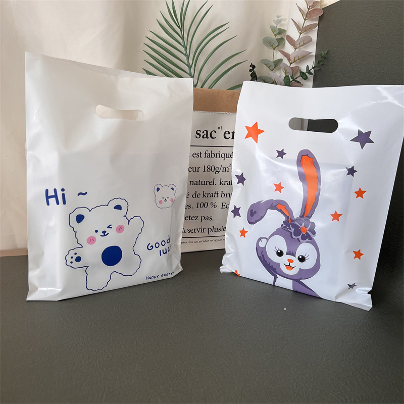 子供服の店の手提げ袋のプラスチックを持って、透明な四本の指を厚くします。