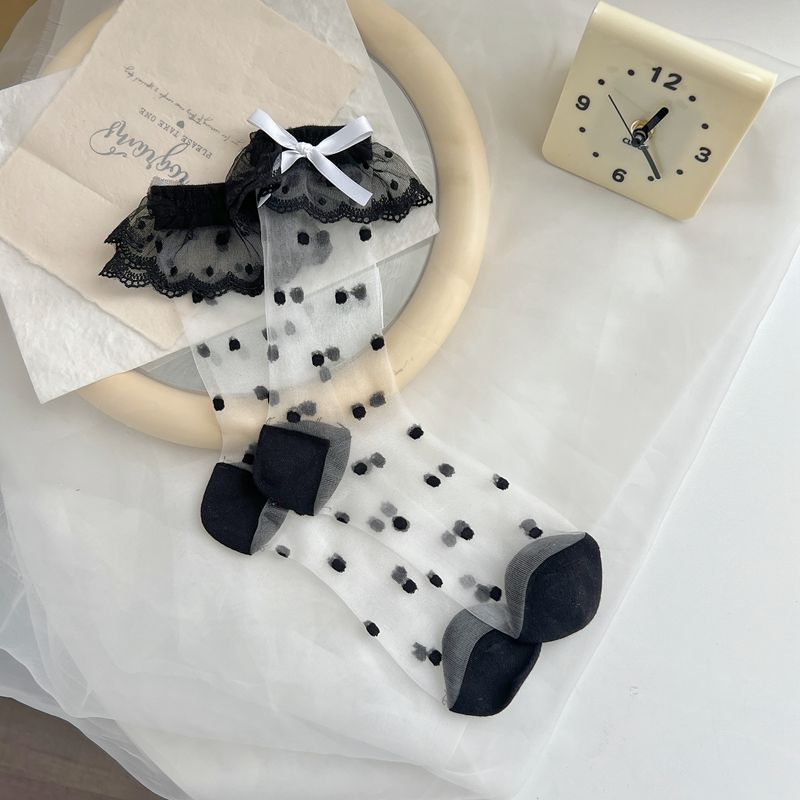흰색 리본이 달린 검은색 물방울 무늬 양말