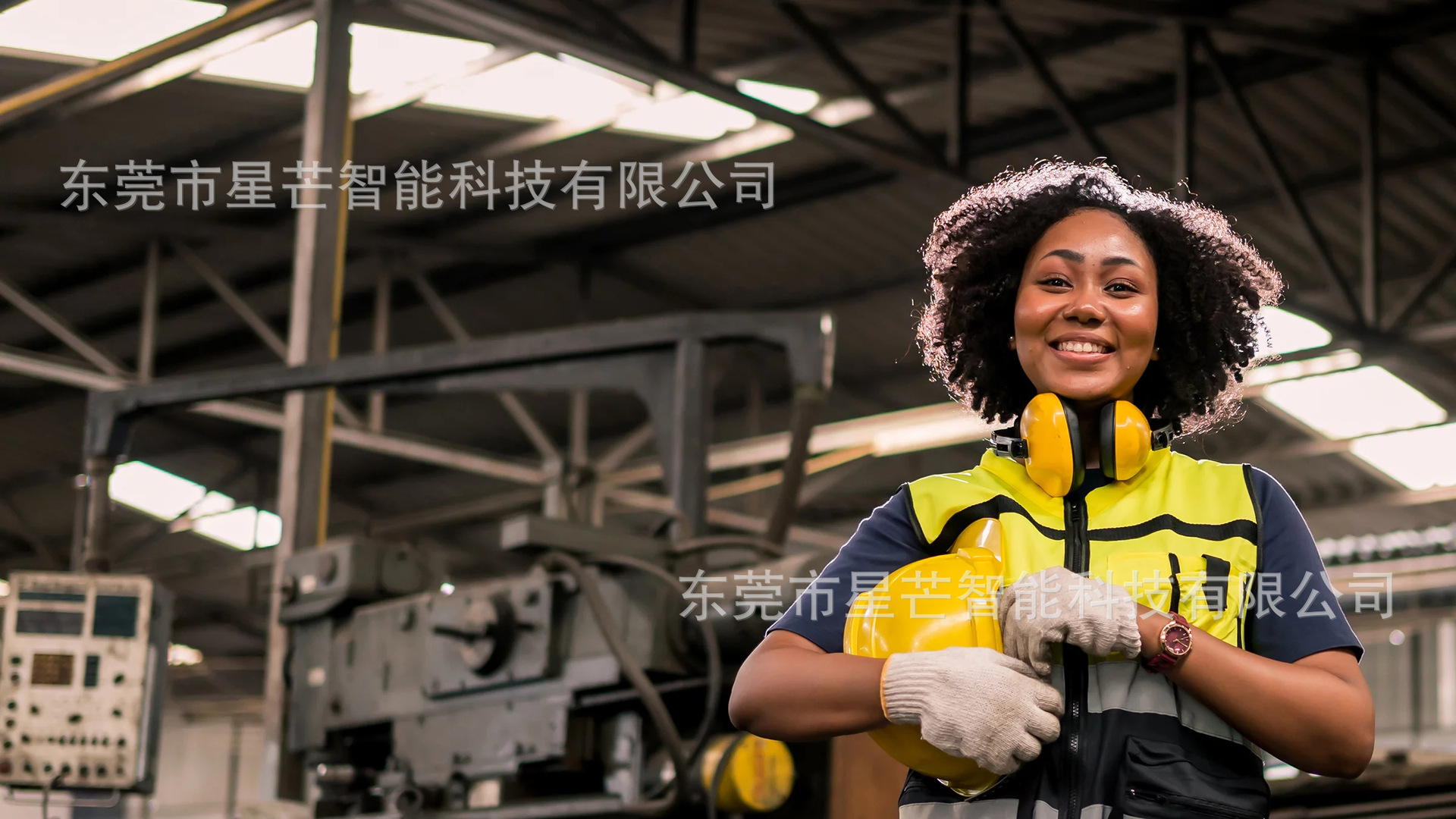 工厂环境中的女工程师穿戴着黄色安全背心、耳机和安全帽站在机器