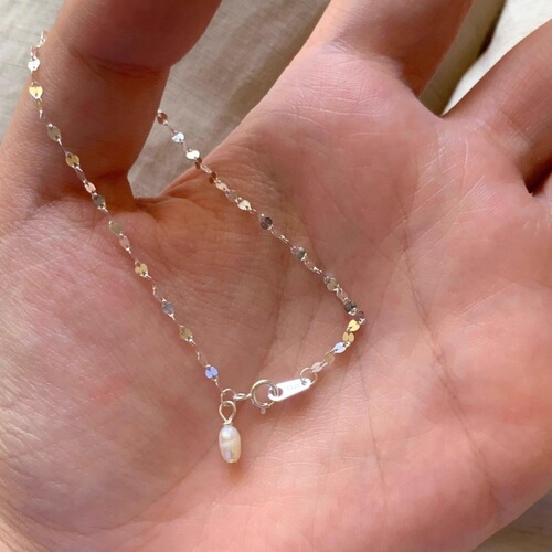 Lustrous wave-like pearl pendant necklace for women, featuring small, exquisite design with a high-end, gentle, and elegant style, suitable for various occasions, crafted with fine rice pearls.