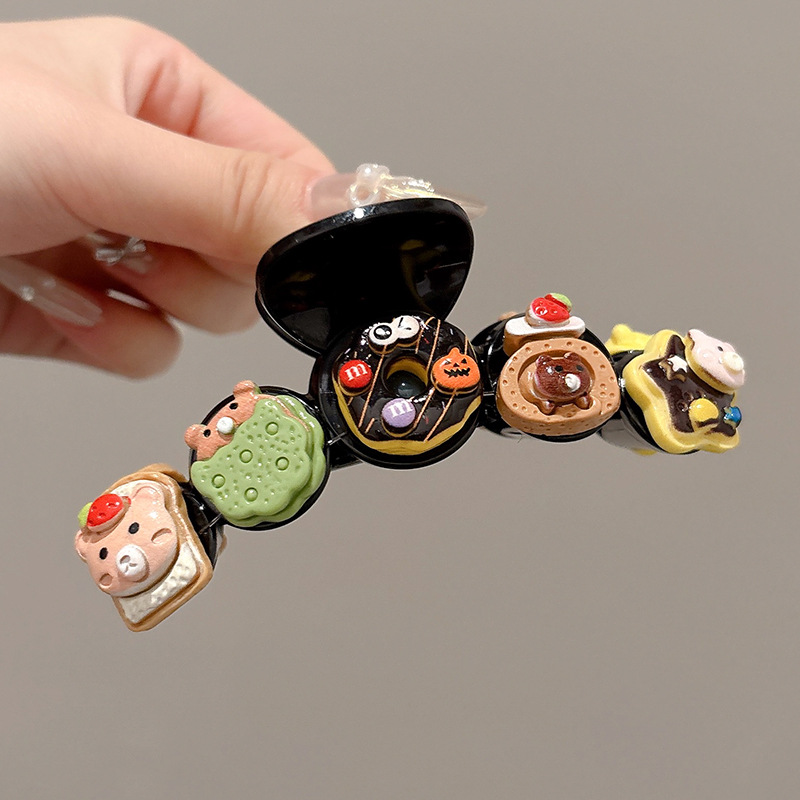 15#Pinza para donuts negra brillante de unos 10 cm.