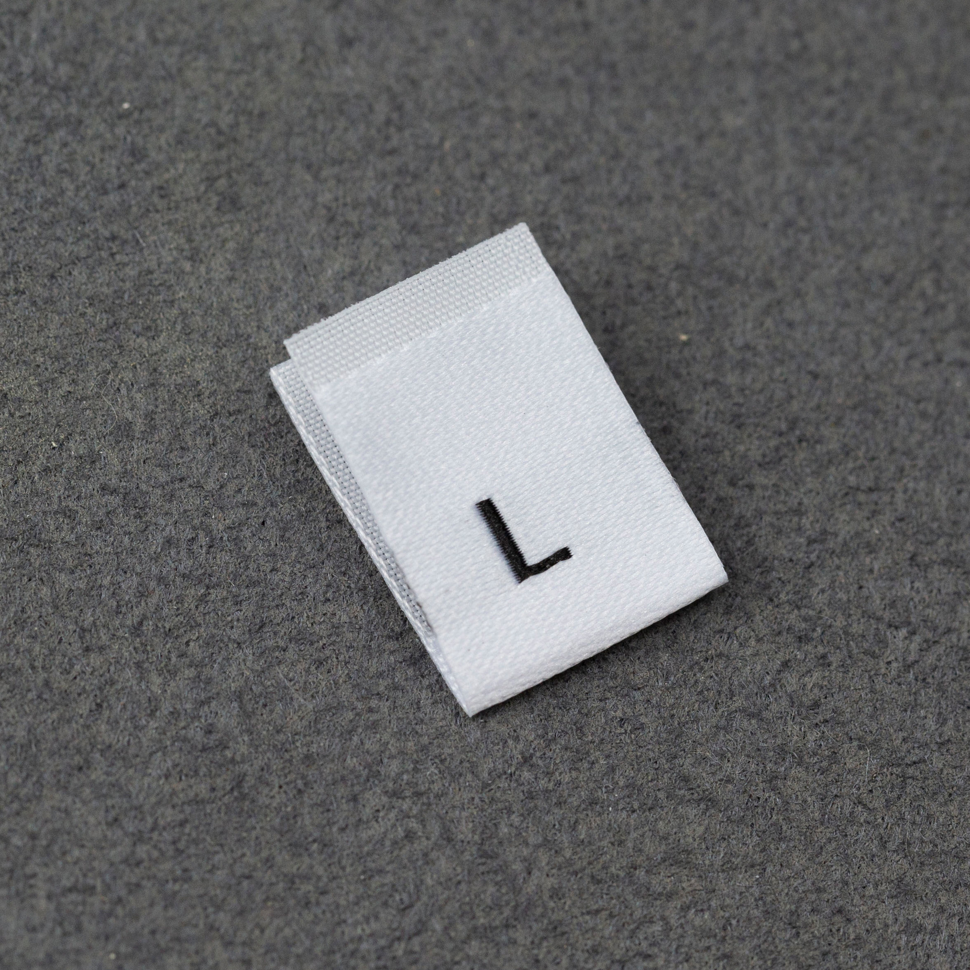 En stock Etiqueta de tamaño de alta densidad en blanco y negro Etiqueta de tamaño universal Etiqueta de código de letra inglesa Pantalones Etiqueta de código de cuello de camiseta