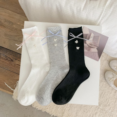 秋の新商品のヨーロッパの女性の靴下の甘いリボンの蝶結びの手は花のボタンのアクセサリーの靴下の純色のスタッキングソックスを縫います。