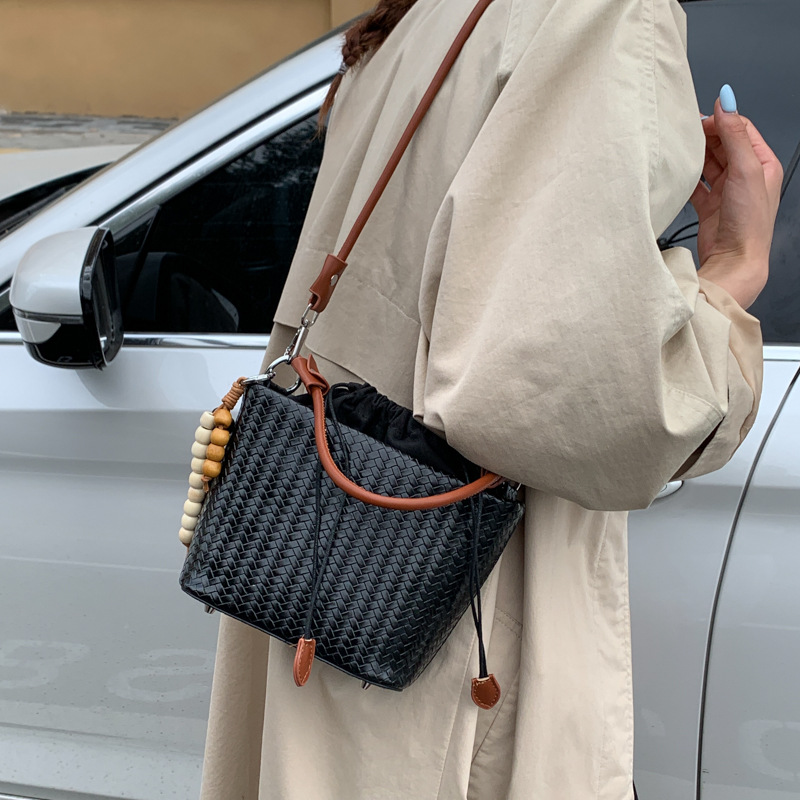 Transfronterizos bolsos de cubo de cuerda bolsos de mujer versátiles bolsos de mano otoño e invierno 2025 nuevo tejido mochila de viaje