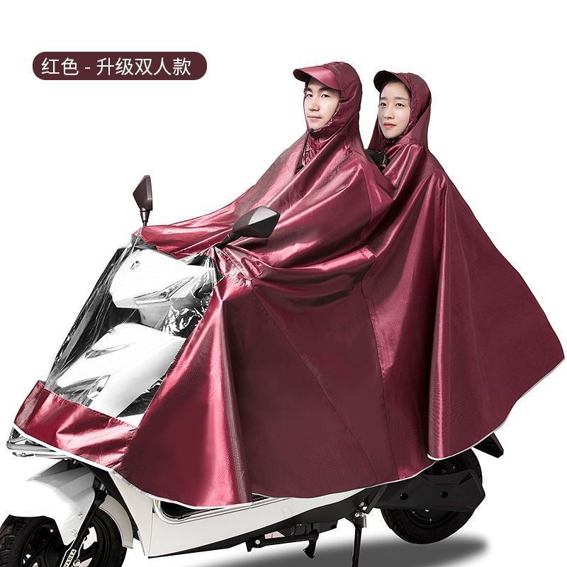 レインコート電気自動車のレインコートを大きくして、オートバイの二人のシングル男性女性が豪雨防止全身に足を隠します。|undefined