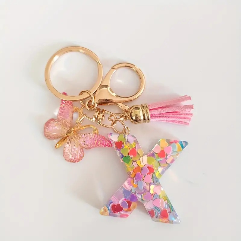 2024 transfronteriza en stock resina rosa con lentejuelas 26 letras inglesas llavero colgante mariposa borla Accesorios