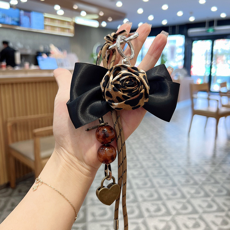 New Leopard Print Bead String Camellia Car Keychain Leather Bow Braided Rope Key Chain Bag Pendant Women's Decoration New Leopard Print Bead String Camellia Car Keychain Leather Bow Braided Rope Key Chain Bag Pendant Women's Decoration