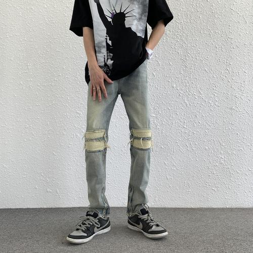 Euro-American trendy high-street light-blue distressed denim jeans for men: vintage-style, slim-fit, tapered legs, with zip-up cuffs—versatile and easy-to-match trousers