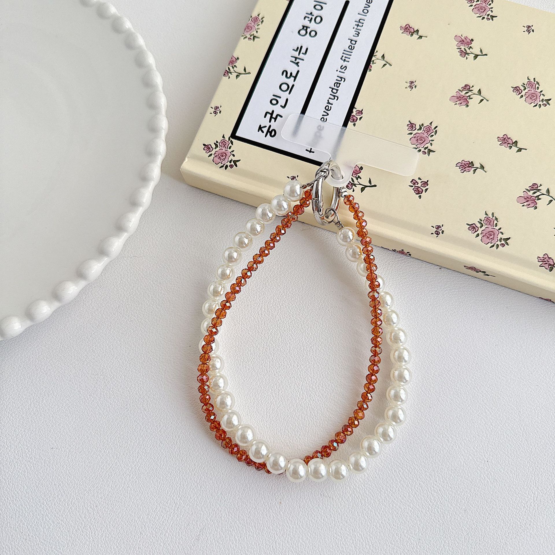 Boutique hecho a mano de alta gama teléfono móvil cadena colgante mujer estilo ins cristal coreano perla enrollamiento cadena de muñeca moda corta