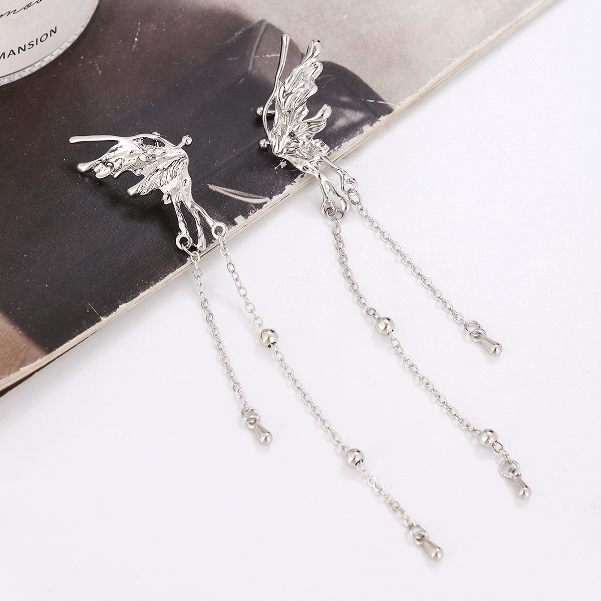 Mariposa europea y americana borla oreja clip de hueso pendientes de una pieza fría de alta gama única cara pequeña oreja clip nicho diseño femenino