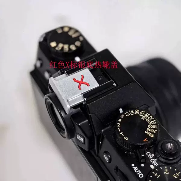 Hot shoe cover with red lettering X mark on silver bottom