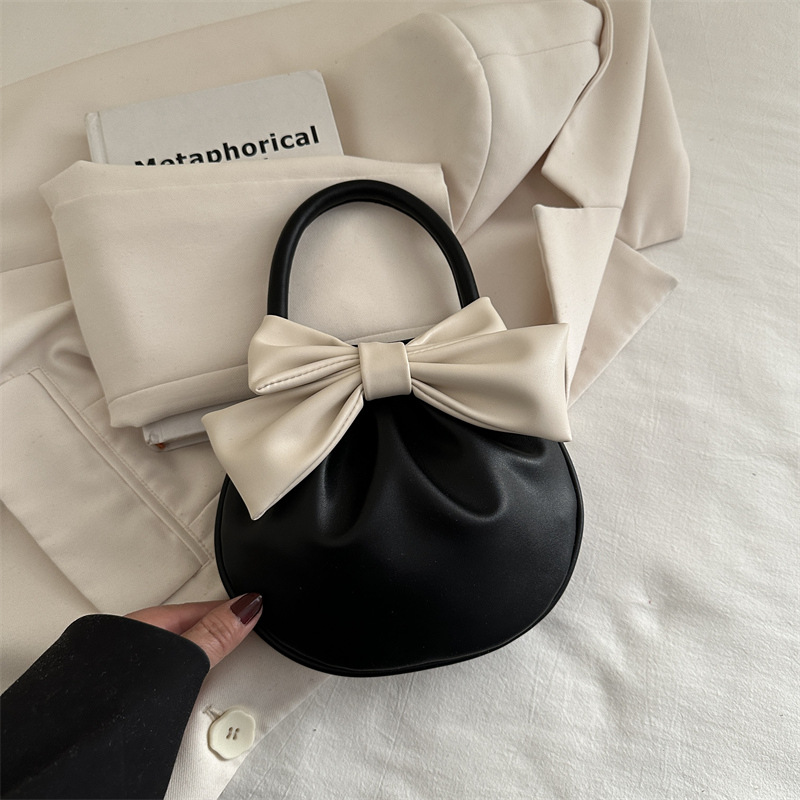 2025 primavera y verano nuevo nicho de diseño de arco bolsos portátiles de mujer alta sensación pequeña bolsa redonda roja