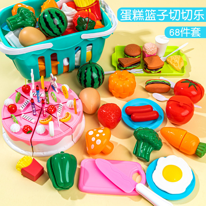 果物を切るおもちゃの切り楽の女の子は野菜のケーキのかごの子供のままごとの台所のおもちゃのセットをシミュレーションします。