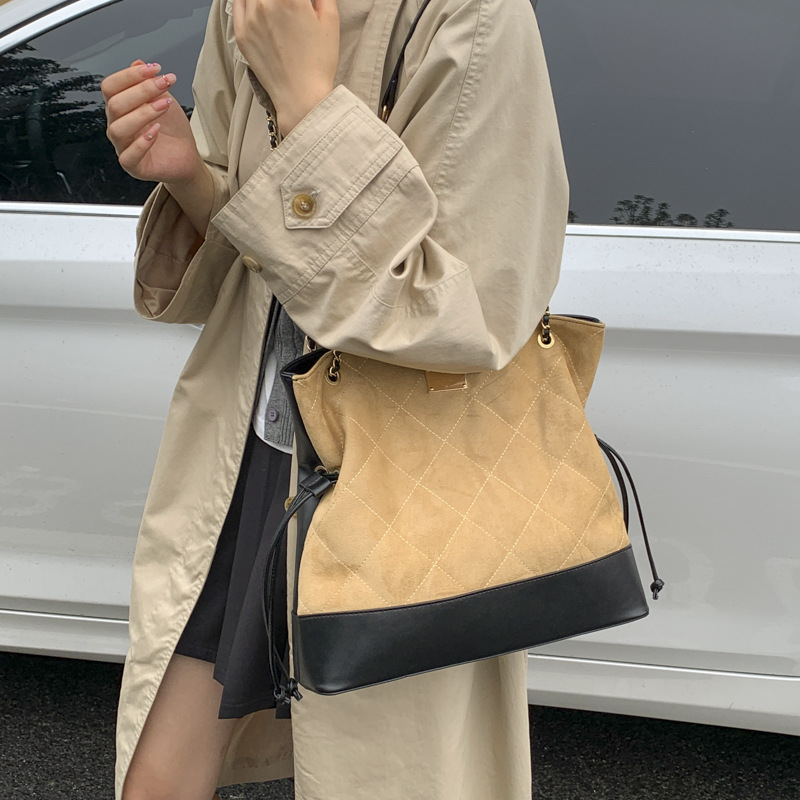 Bolsa de cadena de diamante transfronteriza retro bolso de cubo de agua mujer otoño y invierno 2025 nuevo empalme mochila de hombro de viaje