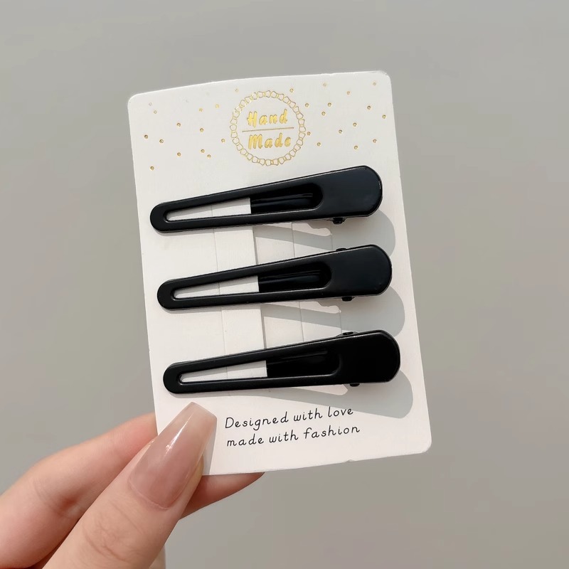 Clipper de cabello de metal negro de alto nivel, frente lateral de la mujer, cabello roto, boca de pato, tocado, clipper para el cabello