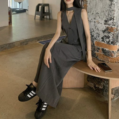 A vintage-style suit set with a sleeveless gray waistcoat for women, featuring a half-body skirt with slits for summer, exuding a sense of elegance - a two-piece set.