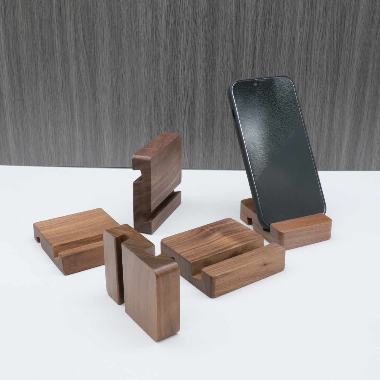 Fabricante mayorista de soporte de teléfono de madera sólida escritorio creativo de madera de avele negro de nuez soporte de teléfono puede imprimir láser en color