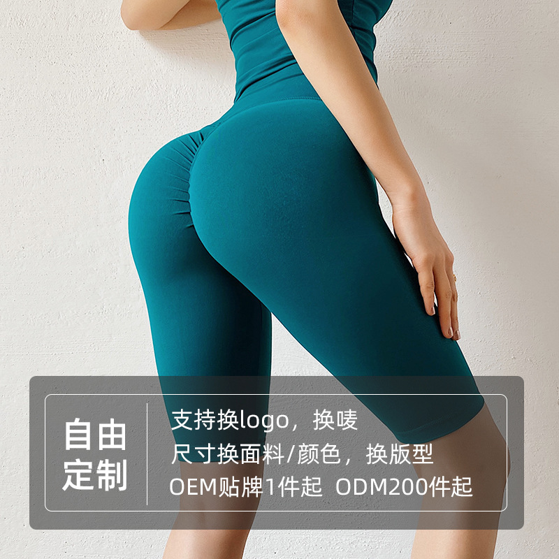 Procesamiento personalizado abrasivo de doble cara sin líneas embarazosas pantalones de gimnasio de miel de melocotón cadera cinco puntos ajustados pantalones cortos de yoga