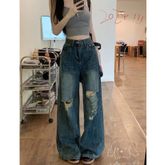夏の穴が開いていて、足がレトロな青い腰の高いジーンズの女性は古い新型のストレートで、背が細くて、ギャルのズボンが見えます。