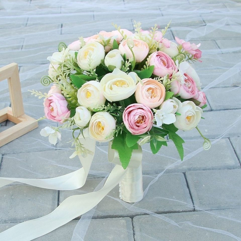 手に花を持つ新婦の韓国式結婚式の領収書のシミュレーションの花束の森系のウェディングドレスの撮影の道具の手に花をささげます。|undefined