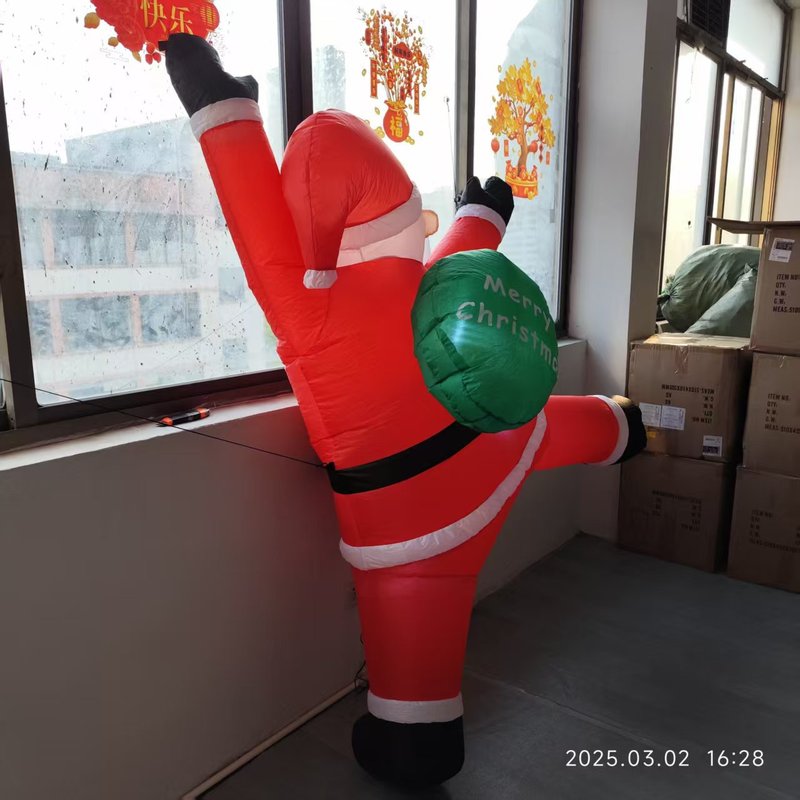 国境を越えた3メートルの壁に登るサンタクロースの空気型グリーンバックパッククリスマスの空気型老人の空気型|undefined