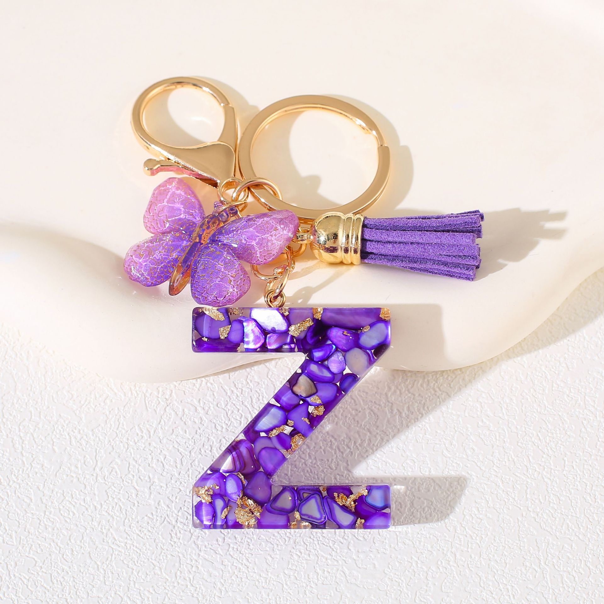 Fábrica directa de Yiwu accesorios de resina de goteo de embalaje llavero anillo de metal letras mariposa brilla colgante damas