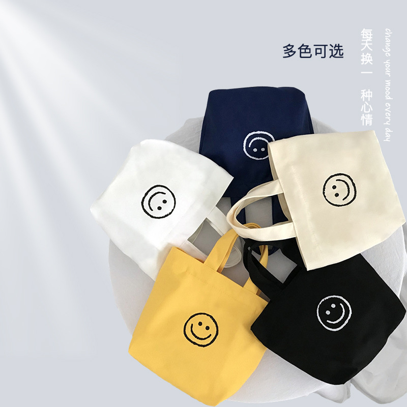 캔버스 가방 여성의 2023 새로운 휴대용 웃는 가방 캐주얼 대학 스타일 학생 작업 올 매치
