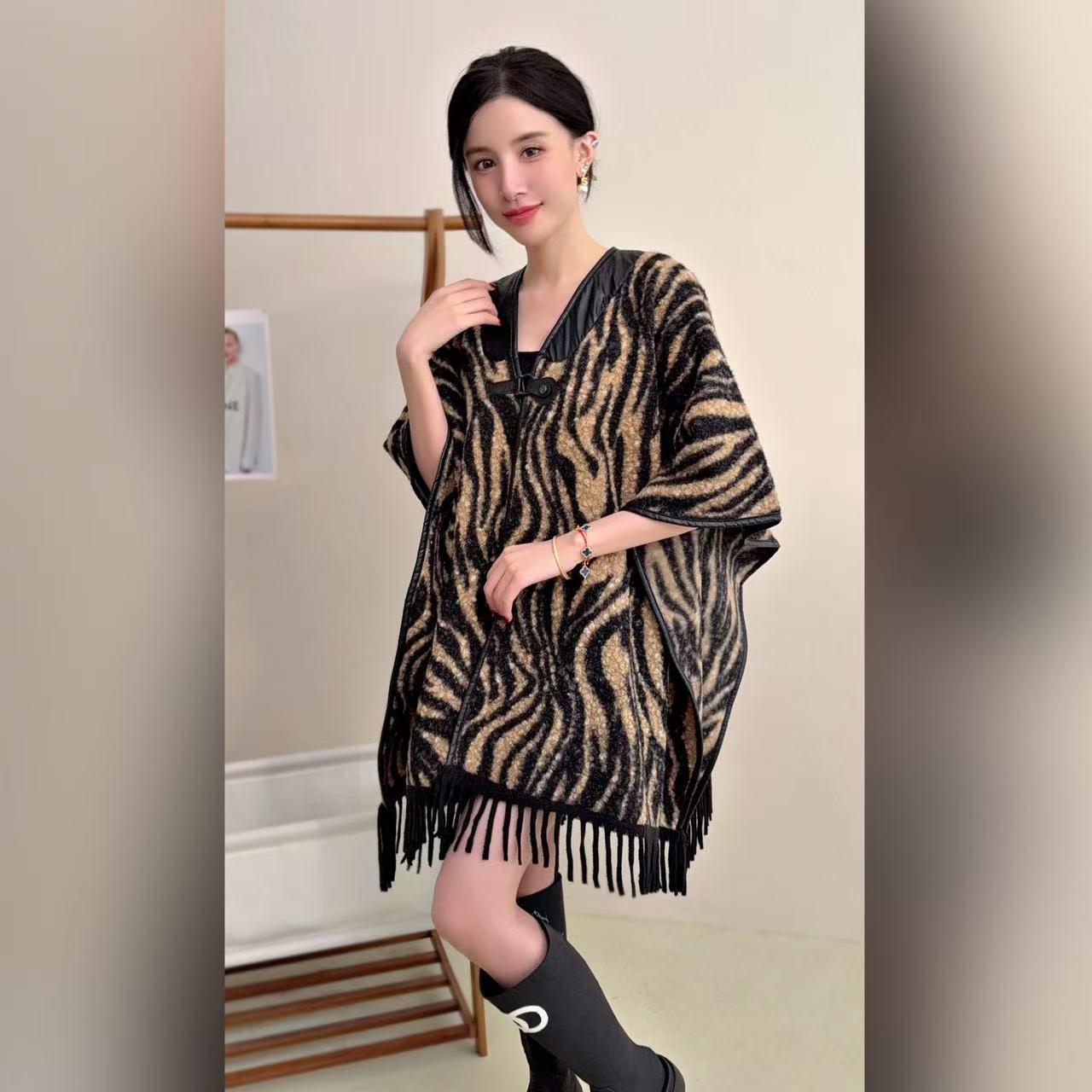 Maillard usa un diseño retro, un suéter de punto con costuras a cuadros de nicho, una capa de estilo occidental para mujer, un chal de borla