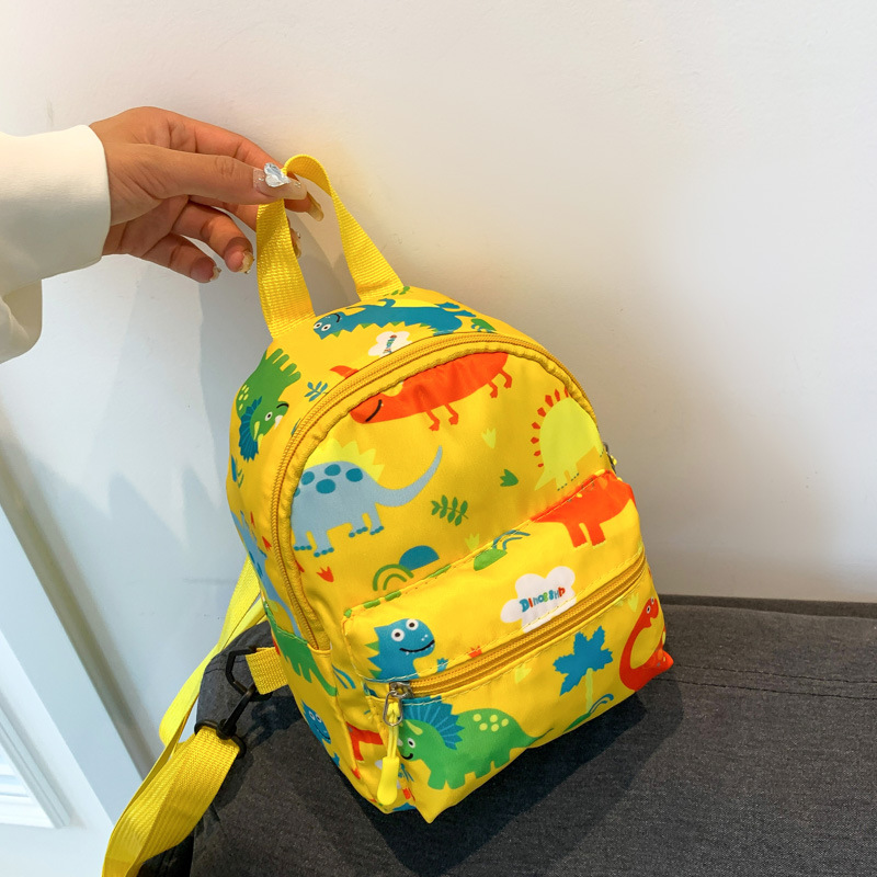 Mochila nueva al por mayor 2025, mochila de tela Oxford con diseño de dinosaurio de dibujos animados, mochila pequeña de gran capacidad para actividades al aire libre y ocio.