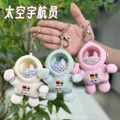 宇宙飛行士の可愛い宇宙飛行士が人形を捕まえる人形を飾っています。