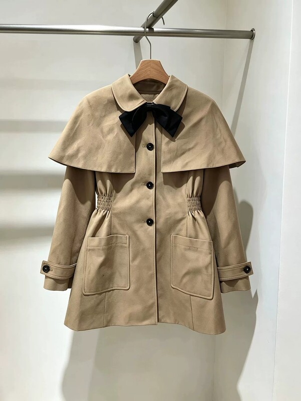 In-stock women's cape trench coat, new autumn style, waist-cinching design, khaki color, with tie and bow detail In-stock women's cape trench coat, new autumn style, waist-cinching design, khaki color, with tie and bow detail