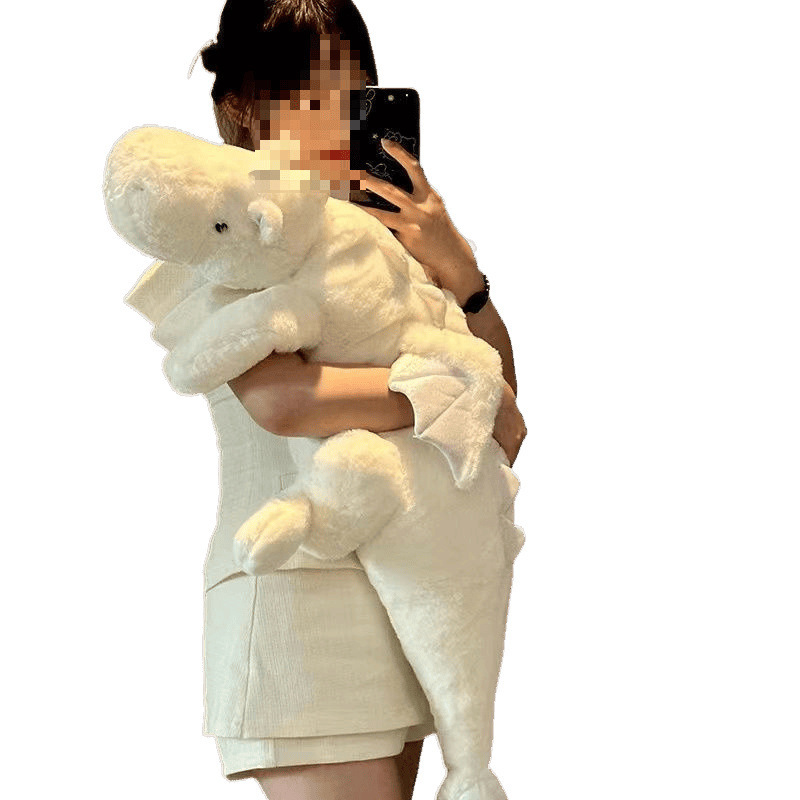 かわいい人形の小飛龍が寝ています。枕を抱いて恐竜のぬいぐるみを抱いて寝ます。|undefined