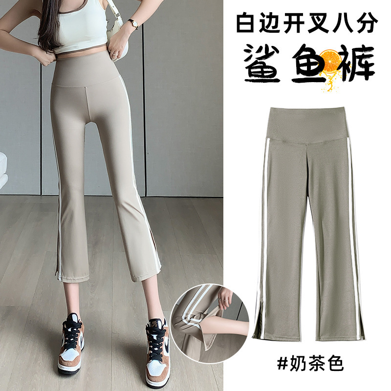白い辺のサメのラッパのズボンの女性の外は夏の薄い金の小さい背の八分の腰を着てフォークを開けます。|undefined