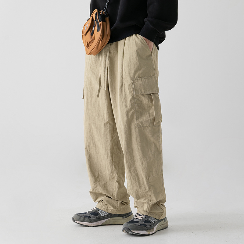 Textura ligeramente arrugada, pantalones de herramientas funcionales antisalpicaduras, estilo de primavera para hombres, pantalones casuales con cordón plisado suelto al aire libre japonés